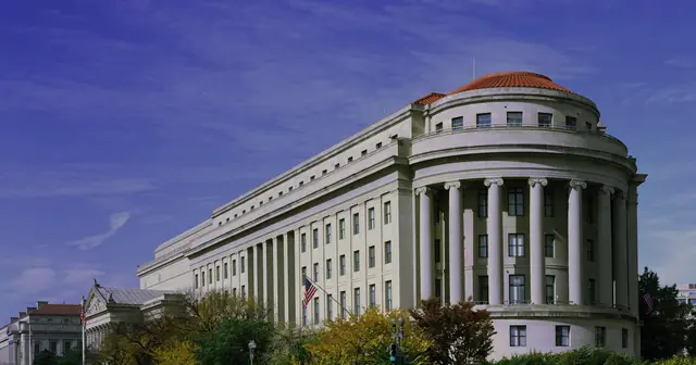 The Apex Building in Washington, D.C., headquarters of the Federal Trade Commission, seen from the street with trees in front.